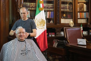 El presidente Andrés Manuel López Obrador difundió este martes una fotografía en la que se observa a Álvaro Cárdenas, su peluquero de años, cortarle el cabello dentro de su oficina de Palacio Nacional. (TWITTER)