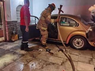 Fuego consume parte de un auto estacionado en la coche de un domicilio del fraccionamiento Filadelfia de Gómez Palacio. (EL SIGLO DE TORREÓN)