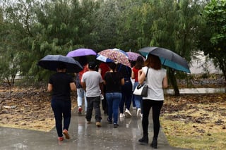 Las personas que sí acudieron a los módulos lo hicieron con paraguas y rompevientos para protegerse de las lluvias. (EL SIGLO DE TORREÓN)