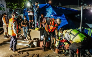 Los más de mil migrantes que pernoctan en un campamento improvisado en Tijuana desde hace meses fueron sorprendidos el jueves en la noche cuando las autoridades de este municipio fronterizo instalaron una valla alrededor de la explanada de El Chaparral. (EFE) 
