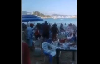 En las imágenes se observa el momento en que algunos meseros arrojan sillas, vasos y platos a otras personas, al parecer los turistas. (ESPECIAL)