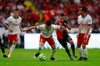 El volante ofensivo charrúa, Brian “Huevo” Lozano, lucha por el balón en medio de tres jugadores del Rebaño Sagrado en el Estadio Jalisco (EFE) 