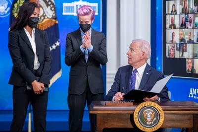 Las integrantes de la selección femenil de Estados Unidos Margaret Purce (i) y Megan Rapinoe, así como el presidente Joe Biden, firmando la proclamación del Día de la Equidad de Pago en la Casa Blanca. (EFE)