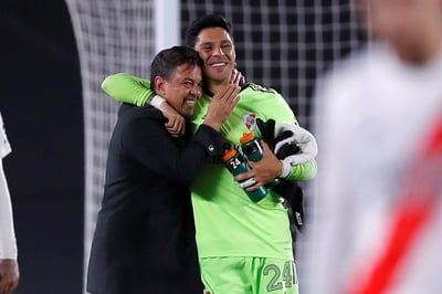 El entrenador Marcelo Gallardo abraza a Enzo Pérez, jugador de campo que tuvo que ponerse los guantes de portero y no admitió gol. (EFE)