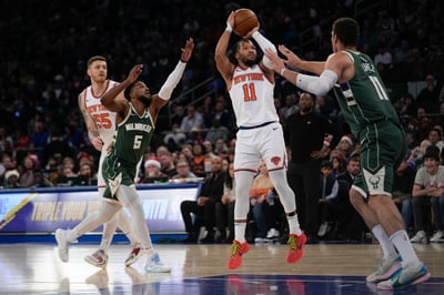 Jalen Brunson de los Knicks de Nueva York lanza el balón sobre Brook Lopez de los Bucks de Milwaukee en el encuentro de la NBA del lunes 25 de diciembre del 2023. (AP Foto/Seth Wenig)