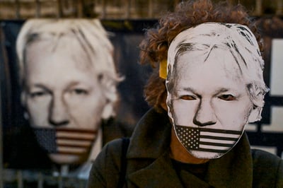 Manifestante con una máscara en apoyo a Julian Assange. (EFE)