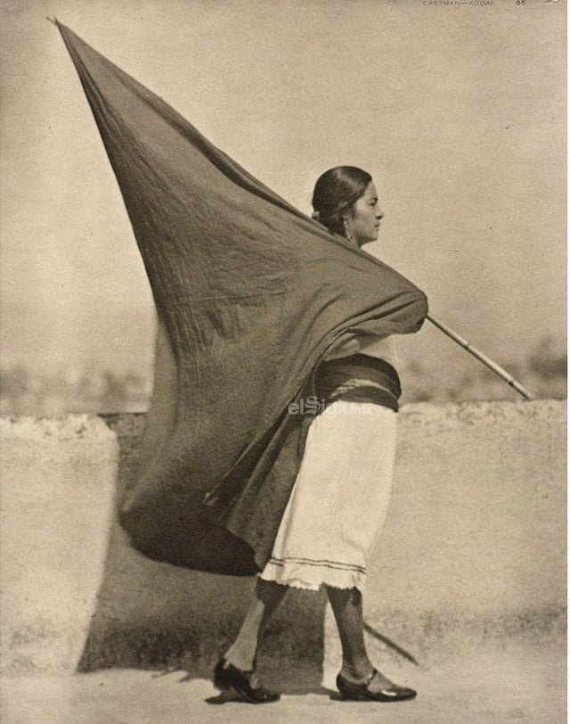 Mujer con bandera negra anarcosindicalista.