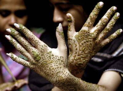 Una mujer pakistaní muestra sus manos decoradas al fin de la celebración del mes santo de Ramadan. Musulmanes alrededor del mundo festejan el mes santo de Ramadán absteniéndose de comer y beber durante el mismo.