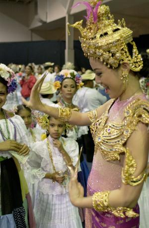 Miss Tailandia, Yaowalak Traisurat muestra a una niños un baile tradicional de su país, durante uno de los recesos del concurso.