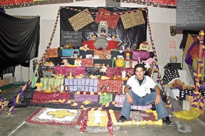 Luis Hernández, junto al altar que montaron los alumnos de sexto grado de la Escuela Carlos Pereyra, a los niños muertos en guerras.