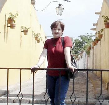 Cristy Cobos de Zea, teniendo como marco el Callejón del Cabildo en la municipalidad de Yanahuara, en su más reciente viaje a la ciudad de Arequipa, Perú.