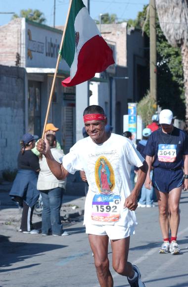 Personajes como “El Diablo” o “La Parca”, son ya reconocidos entre los observadores, que les esperan y aplauden con más ímpetu. El primero, un hombre de lentes que viste short y playera roja, nariz y cuernos de tela, un cetro en cada mano y diez enormes cascabeles en los pies. “La Parca” camina más despacio, lleva un traje completo de pantalón y camisa de manga larga negra, con los “huesos” pintados en blanco, carga además una bandera del Maratón Lala.