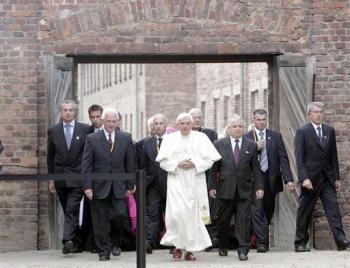 Benedicto XVI ingresó al campo con actitud solemne y las manos unidas luego de pasar bajo la infame puerta como una solitaria figura de blanco.