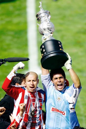 Bautista (izq.) fue el primero en alzar la copa de Campeón frente a los seguidores congregados alrededor de La Minerva, le siguió Oswaldo Sánchez (der.) y el resto del equipo.