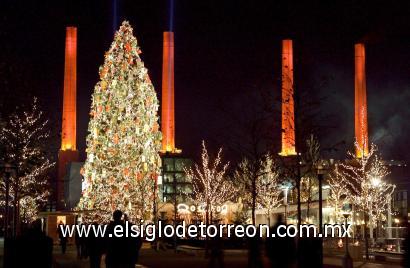 Un árbol de Navidad de 24 metros de alto delante de las cuatro chimeneas iluminadas de rojo en Wolfsburg, conocida como la ciudad del automóvil, en Alemania.