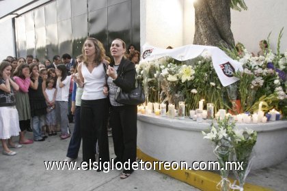 Padres de familia llegaron por la mañana al lugar en donde dejaron flores,   prendieron veladoras y oraron en memoria de la profesora Carla María Jiménez.