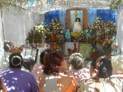 La comunidad con­templa al San­to en el altar mientras otros rezan y entonan canciones religiosas al pequeño niño de Atocha.