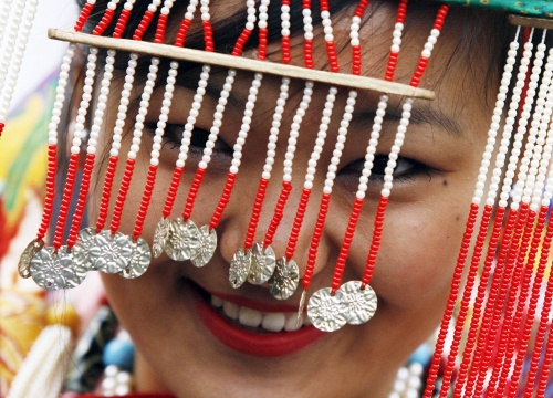 Una joven tibetana con adornos tradicionales sonríe mientras espera la llegada del líder espiritual tibetano, el Dalai Lama, al instituto del Tíbet en Rikon (centro de Suiza). El Dalai Lama realiza una visita de cinco días a Suiza.