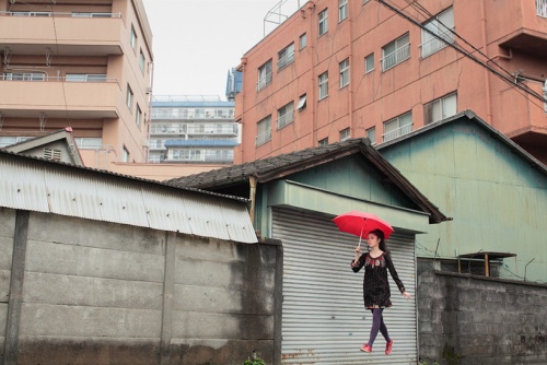 Los edificios desgastados de Tokyo dan un gran apoyo a cada autorretrato.