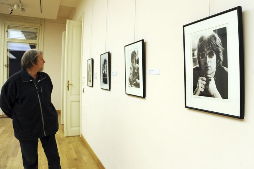 Un visitante observa unas fotografías en la exposición 'El Arte de John Lennon' en el palacio Reok en Szeged.