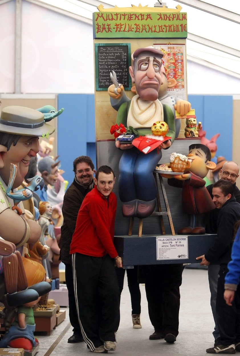 Varios operarios trasladan un ninot en la exposición del Ninot a su lugar.