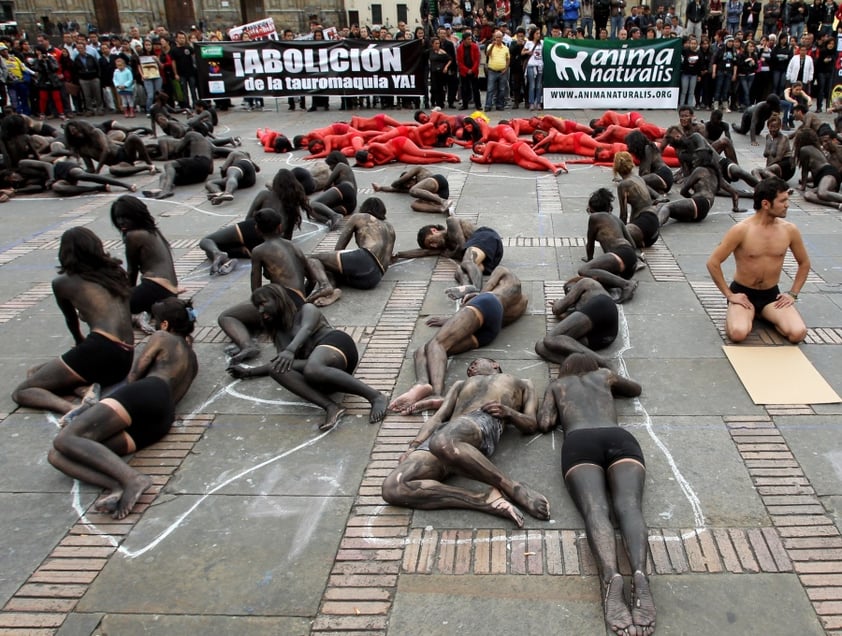 BOG05. BOGOTÁ (COLOMBIA), 09/02/2012.- Unas 70 personas semidesnudas y pintadas de rojo y negro se manifiestan para reclamar el fin de las corridas de toros en el país hoy, jueves 9 de febrero de 2012, en la Plaza de Bolívar de Bogotá (Colombia). El debate antitaurino resucitó en Colombia a mediados de enero cuando arrancó la temporada de toros en una de sus plazas predilectas, la de Santamaría en Bogotá, y tuvo su germen en la decisión del nuevo alcalde capitalino, Gustavo Petro, de no ocupar el palco de la Alcaldía. EFE/Mauricio Dueñas