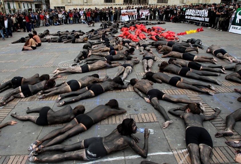 BOG03. BOGOTÁ (COLOMBIA), 09/02/2012.- Unas 70 personas semidesnudas y pintadas de rojo y negro se manifiestan para reclamar el fin de las corridas de toros en el país hoy, jueves 9 de febrero de 2012, en la Plaza de Bolívar de Bogotá (Colombia). El debate antitaurino resucitó en Colombia a mediados de enero cuando arrancó la temporada de toros en una de sus plazas predilectas, la de Santamaría en Bogotá, y tuvo su germen en la decisión del nuevo alcalde capitalino, Gustavo Petro, de no ocupar el palco de la Alcaldía. EFE/Mauricio Dueñas