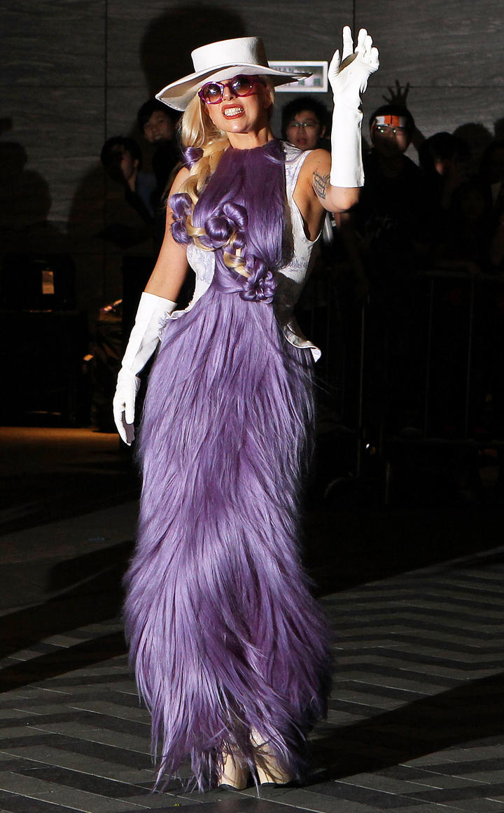 Al llegar al aeropuerto de Hong Kong,  la intérprete de Bad Romance llamó la atención por lucir un vestido hecho de una especie de cabello morado.