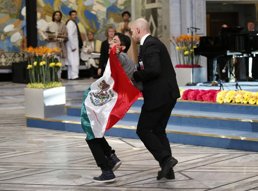 El activista siguó mostrando la bandera mexicana mientras era retirado del lugar.