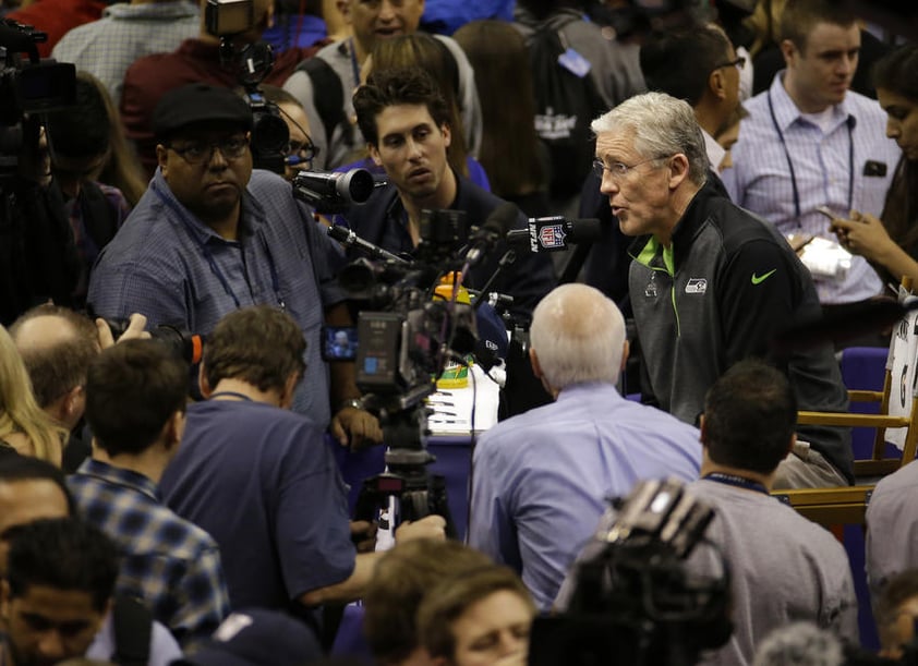 Pete Carroll rodeado de medios.