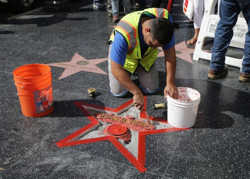 HOLLYWOOD (CA, EE.UU.).- Un trabajador latino repara la estrella del actual candidato republicano a la Presidencia de EE.UU., Donald Trump, en el Paseo de la Fama de Hollywood, California. La estrella fue destrozada por un vándalo durante la pasada madrugada. EFE