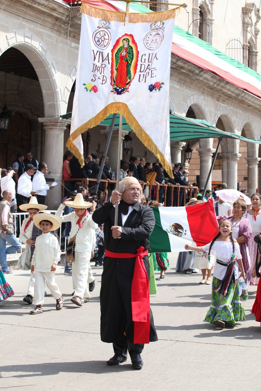 La representación de Miguel Hidalgo con un estandarte de la virgen de Guadalupe.