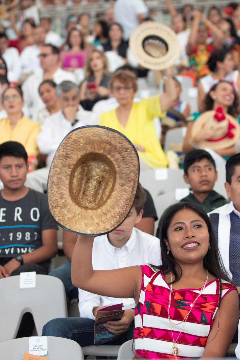 En tanto que el término hace referencia en la lengua zapoteca a las ideas de cooperar y reciprocidad, en la fiesta se relaciona con el hecho de compartir con el público algunos de los productos que se producen en sus regiones, como frutas objetos de barro, tortillas, entre mucho más.