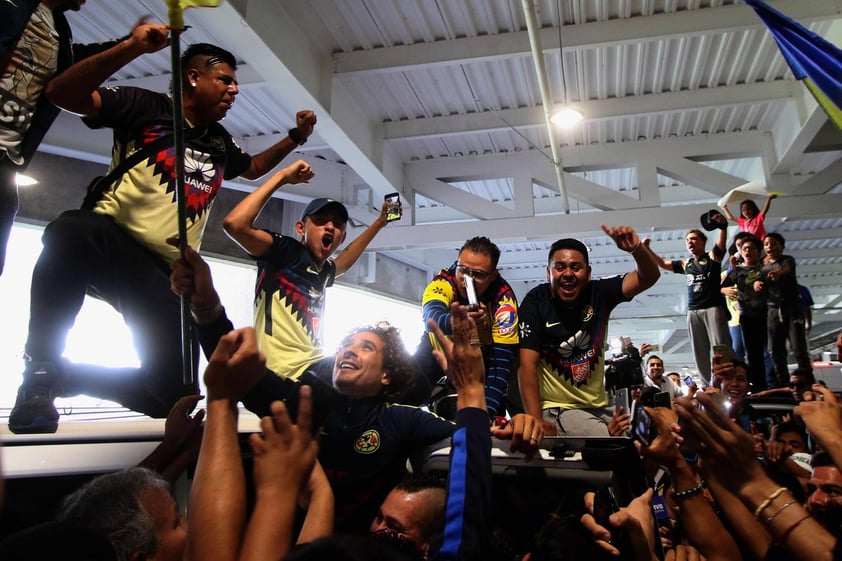 Decenas de aficionados del América se movieron entre empujones y alguno se subió en la camioneta en la que fue trasladado el jugador, quien será titular con el América tras la salida del argentino Agustín Marchesín al Oporto de Portugal.