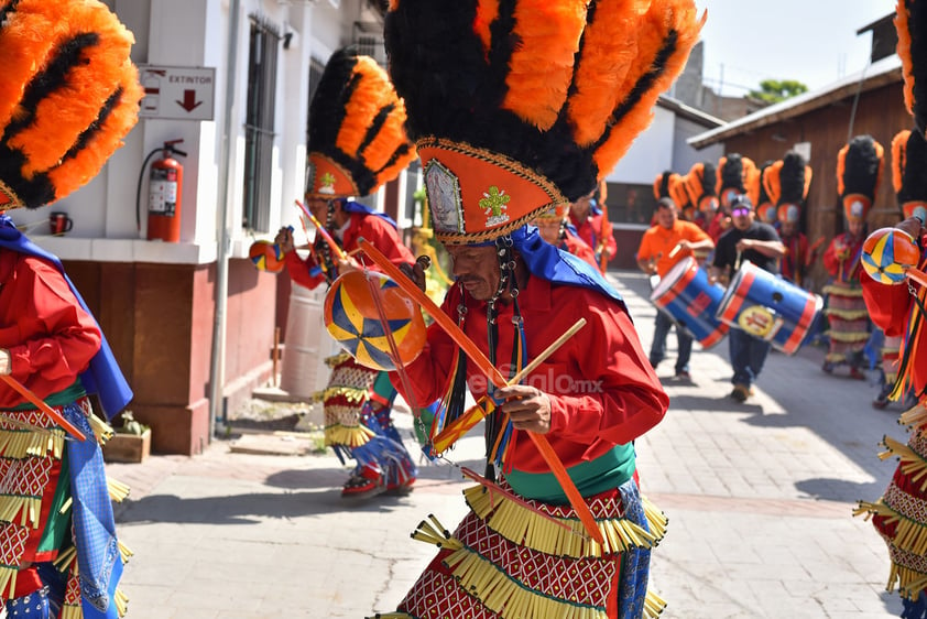 Los devotos visten en nahuillas. Sus penachos apuntan al cielo con plumas naranjas y negras.