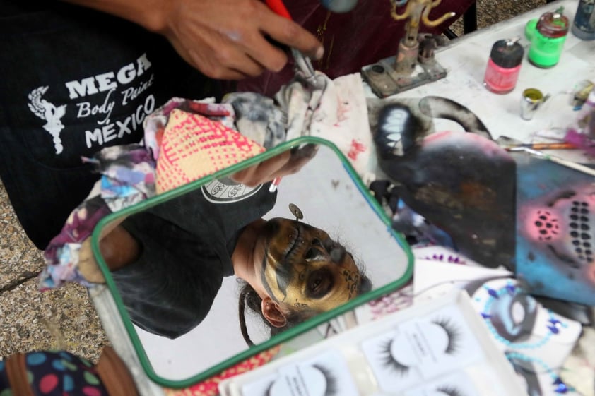 Aspectos del maquillaje de Catrinas que se realiza en la glorieta del Ángel de la Independencia previo la Megaprocesión de Catrinas que llegará al Zócalo capitalino.