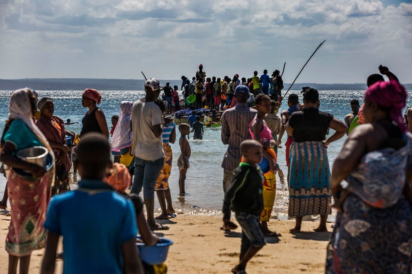 Pasajeros y carga a bordo de un bote desde una playa de pescadores que se ha convertido en uno de los principales puntos de llegada de personas desplazadas.