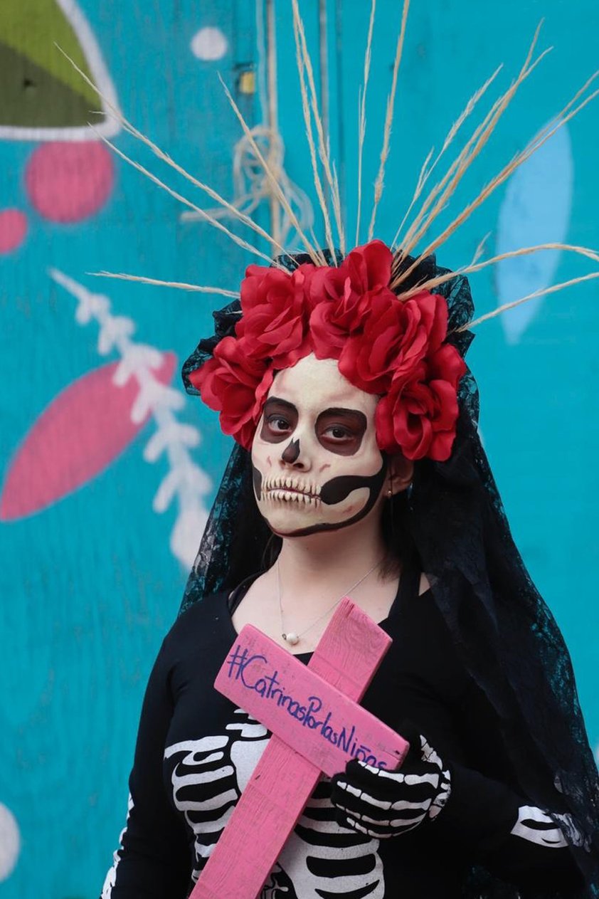 A la convocatoria se unió un grupo de unas 20 mujeres vestidas de catrinas blancas, en cuyos vestidos colgaron fotos de las mujeres que han sido halladas sin vida en el Río de los Remedios, en el Estado de México.