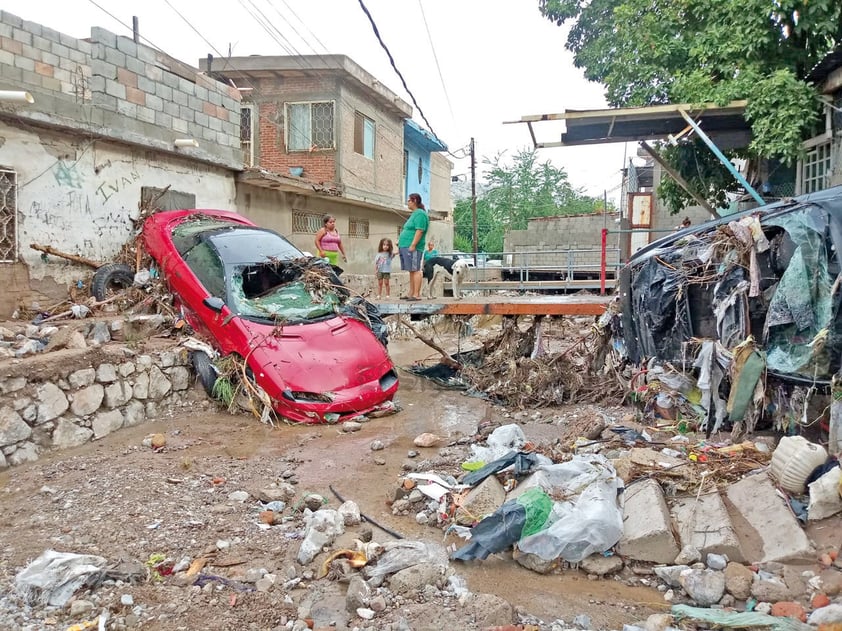 Caos y destrucción. Estos automóviles Camaro rojo y un Volvo, del mismo dueño, fueron arrastrados unos 500 metros por la fuerte corriente.