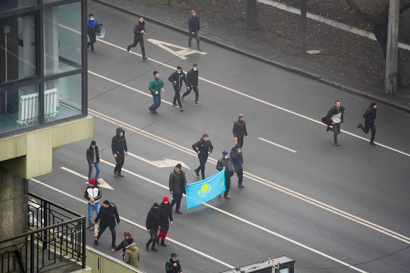 Demonstrators with Kazakhstan's national flag march during a protest in Almaty, Kazakhstan, Wednesday, Jan. 5, 2022. Demonstrators denouncing the doubling of prices for liquefied gas have clashed with police in Kazakhstan's largest city and held protests in about a dozen other cities in the country. (AP Photo/Vladimir Tretyakov)