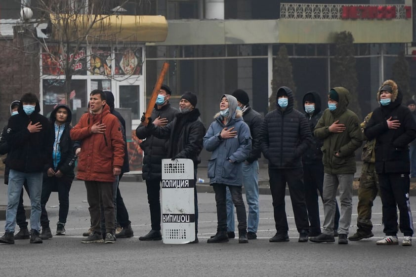 Demonstrators sing the Kazakhstan's national anthem standing in front of police line during a protest in Almaty, Kazakhstan, Wednesday, Jan. 5, 2022. Demonstrators denouncing the doubling of prices for liquefied gas have clashed with police in Kazakhstan's largest city and held protests in about a dozen other cities in the country. (AP Photo/Vladimir Tretyakov)