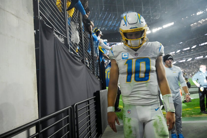 Los Angeles Chargers quarterback Justin Herbert (10) walks off the field after the Los Angeles Chargers lost to the Las Vegas Raiders in overtime of an NFL football game, Sunday, Jan. 9, 2022, in Las Vegas. (AP Photo/David Becker)