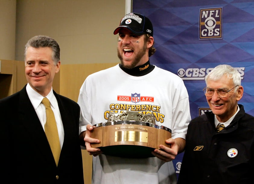 FILE - Pittsburgh Steelers quarterback Ben Roethlisberger, center, holds the AFC Championship trophy with Steelers president Art Rooney III, left, and Chairman Dan Rooney after Pittsburgh advanced to Super Bowl XL with a 34-17 win over the Denver Broncos Sunday, Jan. 22, 2006, in Denver. Ben Roethlisberger's NFL career is over. The longtime Pittsburgh Steelers quarterback announced his retirement on Thursday, Jan. 27, 2022, saying it was “time to clean out my locker, hang up my cleats” after 18 years, two Super Bowls, countless team records and a spot in the Hall of Fame all but secure. (AP Photo/Gene J. Puskar, File)