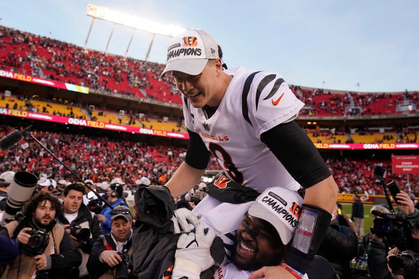 Cincinnati Bengals quarterback Joe Burrow (9) celebrates with teammate Tyler Shelvin at the end of the AFC championship NFL football game against the Kansas City Chiefs, Sunday, Jan. 30, 2022, in Kansas City, Mo. The Bengals won 27-24 in overtime. (AP Photo/Charlie Riedel)