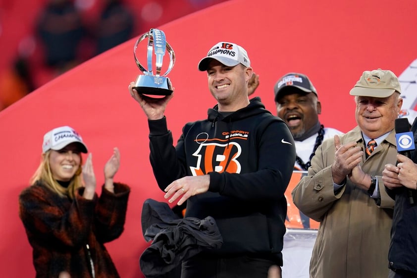 Cincinnati Bengals head coach Zac Taylor holds up the Lamar Hunt trophy as team owner Mike Brown, right, looks on after the AFC championship NFL football game against the Kansas City Chiefs, Sunday, Jan. 30, 2022, in Kansas City, Mo. The Bengals won 27-24. (AP Photo/Paul Sancya)