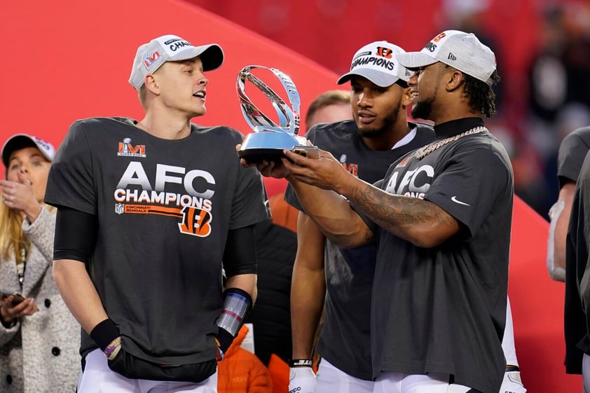 Cincinnati Bengals quarterback Joe Burrow, left, celebrates with teammates as they hold the Lamar Hunt trophy after the AFC championship NFL football game against the Kansas City Chiefs, Sunday, Jan. 30, 2022, in Kansas City, Mo. The Bengals won 27-24 in overtime. (AP Photo/Paul Sancya)