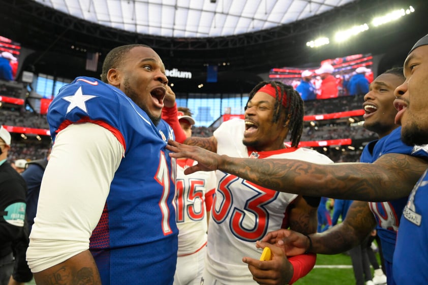 NFC inside linebacker Micah Parsons, left, of the Dallas Cowboys, reacts with AFC safety Derwin James (33), of the Los Angeles Chargers, after the Pro Bowl NFL football game, Sunday, Feb. 6, 2022, in Las Vegas. (AP Photo/David Becker)