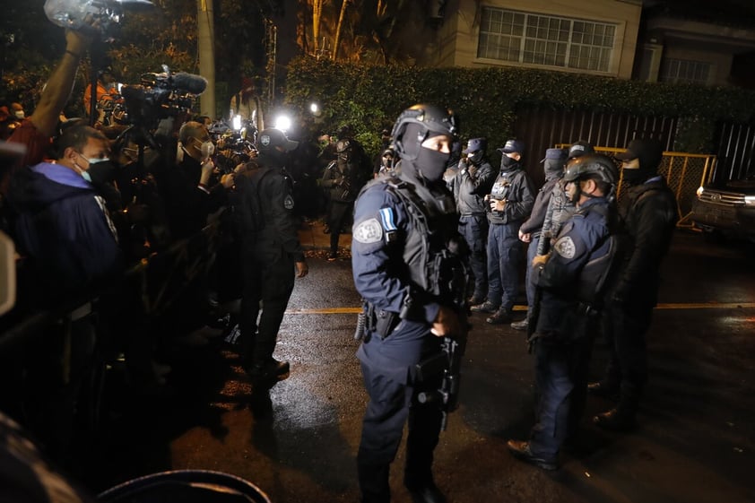 AME5798. TEGUCIGALPA (HONDURAS), 14/02/2022.- Agentes policiales rodean la casa del expresidente hondureño Juan Orlando Hernández, mientras periodistas realizan cubrimiento en Tegucigalpa (Honduras). Fuerzas de seguridad de Honduras con fusiles de asalto se han apostado esta noche en los alrededores de la residencia del expresidente Juan Orlando Hernández, quien habría sido solicitado en extradición por Estados Unidos. El movimiento policial se produjo después de que la Cancillería hondureña informara en Twitter que 'ha remitido a la CSJ (Corte Suprema de Justicia) comunicación oficial de la Embajada de los EEUU, solicitando formal arresto de un político hondureño con el propósito de extradición'. EFE/ Gustavo Amador