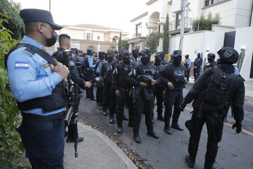 AME5892. TEGUCIGALPA (HONDURAS), 15/02/2022.- Agentes de policía y periodistas esperan en las afueras de la casa del expresidente Juan Orlando Hernández hoy, en Tegucigalpa (Honduras). Los alrededores de la residencia de Hernández se encuentran bajo un riguroso dispositivo de seguridad desde el lunes en la noche, después de que la Cancillería informara de que Estados Unidos ha solicitado un 'formal arresto provisional de un político hondureño con el propósito de extradición' a ese país. EFE/ Gustavo Amador