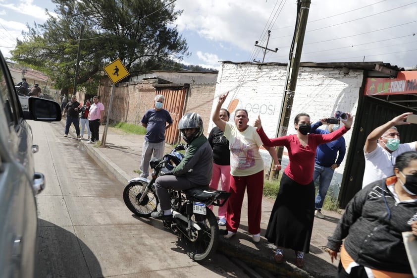 AME6003. TEGUCIGALPA (HONDURAS), 15/02/2022.- Habitantes salen al paso de la caravana que traslada al expresidente hondureño Juan Orlando Hernández a la dirección de las Fuerzas Especiales, tras su captura en Tegucigalpa. Hernández fue capturado este martes, en su casa en la capital hondureña y trasladado supuestamente a rendir su primera declaración ante un juez natural que ordenó su detención, luego EE.UU. lo solicitará, con fines de extradición, por narcotráfico entre otros delitos. EFE/ Gustavo Amador